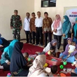 Pemdes Jiwan dan aparat desa lainnya saat meninjau balai dusun yang digunakan untuk membagikan makanan tambahan.