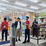 Petugas Polres Mojokerto Kota sedang menanyai sejumlah saksi di minimarket.