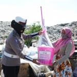 Polwan Satlantas Polres Gresik membagikan sembako kepada paskun di TPA Ngipik. foto: ist.