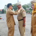 Sekda Ir. Didik Budi Mulyono memasangkan tanda pengenal kepada salah satu kepala desa.