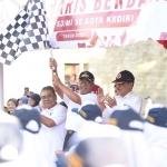 Wakil Wali Kota Kediri Qowimuddin (mengibarkan bendera) saat memberangkatkan peserta lomba baris tingkat SMP/MTs. Foto: Ist. 