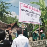 Puluhan personel dari Mapolres Tuban mengamankan penyitaan lahan sengketa oleh PN Tuban. foto: GUNAWAN/ BANGSAONLINE
