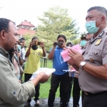 Wakapolres Bangkalan Kompol Deky Hemansyah secara simbolis memberikan vitamin dan masker ke Ahmad Fauzi, salah satu Jurnalis Bangkalan dari HARIAN BANGSA.