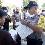 Bripka Hendriko NC membagikan masker kain gratis dan sosialisasi kepada masyarakat sebagai pencegahan mewabahnya Virus Corona (Covid-19).