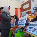 Pjs Bupati Trenggalek, Dyah Wahyu, saat menyalurkan uang ganti rugi proyek pembangunan Dam Bagong pada warga terdampak.