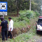 Sejumlah petugas sedang memasang rambu-rambu jalur evakuasi.