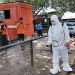 Tim BPBD Jatim saat menyemprotkan disinfektan guna mencegah penyebaran penyakit mulut dan kuku (PMK) pada hewan ternak. Foto: Ist