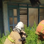 Petugas pemadam kebakaran saat menjinakkan api yang membakar sebuah rumah kosong di Surabaya.