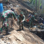 Pekerjaan menaikkan dan menurunkan pasir dari atas truk yang dilakukan Satgas TMMD ke-106 Kodim Malang-Batu.