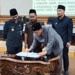Qosim, Yani, dan Alif menyaksikan Wakil Ketua DPRD Gresik Mujid Riduan tandatangani nota APBD. foto: SYUHUD/ BANGSAONLINE
