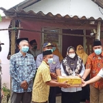 Bu Min didampingi Kepala BPBD Tarso Sagito dan Camat Cerme Suyono saat menyerahkan bantuan kepada keluarga korban siswa SMP tenggelam di Waduk Cerme Kidul, Sabtu (30/1). foto: SYUHUD/ BANGSAONLINE