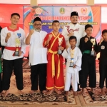 Plt. Wali Kota Pasuruan Raharto Teno Prasetyo, S.T. foto bersama para pemenang usai menyerahkan trofi kejuaraan pencak silat antar perguruan se-Kota Pasuruan.