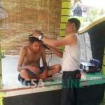 Ghani saat mencukur orang gila yang mulai melunak kepadanya. foto: andi sirajudin/ BANGSAONLINE
