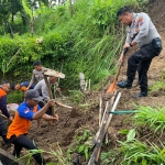 Personel Polres Madiun bersama warga dan instansi terkait membantu membersihkan material longsor. Foto: Dok. Humas Polres Madiun.