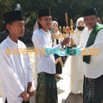 Plt Bupati Nganjuk, Marhaen Djumadi, saat memberikan piala penghargaan kepada Santri Juara II MTQ tingkat Nasional. Foto: BAMBANG DWI JULAINTO/BANGSAONLINE