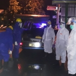 Petugas mengenakan APD lengkap mengevakuasi korban yang meninggal mendadak di Buduran.