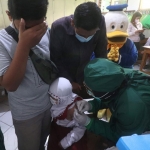 Wali Kota Kediri, Abdullah Abu Bakar, ikut menenangkan salah satu siswi yang ketakutan saat disuntik vaksin Covid-19. Foto: Ist