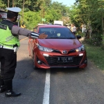 Petugas di pos penyekatan menghentikan kendaraan yang hendak masuk Blitar Raya.