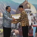 Wabup Moh. Qosim saat menerima penghargaan dari Gubernur Jatim, H. Soekarwo. foto: SYUHUD/ BANGSAONLINE
