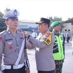 Kapolres Kediri AKBP Agung Setyo Nugroho saat menyematkan pita kepada salah seorang petugas