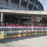 Ratusan buruh Smelting membentangkan spanduk raksasa di depan Stadion Gejos. foto: syuhud/ bangsaonline