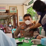 Kapolsek Tandes Kompol Ricky Tri Dharma, S.H., S.I.K., saat mengikuti penyuntikan vaksinasi Covid-19 dosis pertama di Puskesmas Manukan Kulon. (foto: ist)