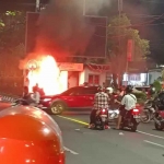 Massa aksi saat membakar pos polisi di Jalan Panglima Sudirman, Surabaya.