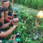 Sejumlah awak media mengabadikan api yang menyala dari retakan tanah di sawah Desa Bendo, Kecamatan Pangkur. foto: ZAINAL A/ BANGSAONLINE