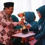 Ketua TP PKK Gresik, Hj.Maria Ulfa ketika menerima penghargaan dari Gubernur Jatim, Soekarwo. foto: SYUHUD/ BANGSAONLINE