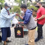 Kepala BPSDM Aries Agung Pawai (kaos merah) bersama Ketua Pokja Wartawan Pemprov Jatim Fiqih Arfani saat membagi hewan kurban.