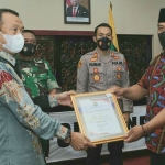 Bupati Sumenep, Achmad Fauzi, saat memberi penghargaan kepada kecamatan dan desa/kelurahan yang telah melakukan percepatan vaksinasi Covid-19 terbaik.