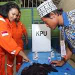 Salah satu pekerja menyelupkan jari ke tinta tanda usai mencoblos.