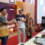 Dedy Kurniawan, Founder Bromo Marathon, saat memberikan blangkon khas suku tengger kepada Bupati Irsyad Yusuf.