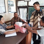 Anggota Polsek Nongkojajar tampak mengenakan baju batik saat memberikan pelayanan kepada masyarakat. Foto: ANDY F/BANGSAONLINE