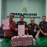 Kajari Gresik Nana Riana didampingi Kasi Pidsus dan Kasi Intel menunjukan pengembalian uang dugaan korupsi Rp1,3 miliar. Foto: SYUHUD/ BANGSAONLINE