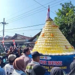 Tumpeng tahu kuning dan hasil bumi sebelum diperebutkan warga. Foto: Muji Harjita.