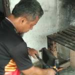 Pamungkas saat melakukan reparasi radiator. foto: Yuniardi Sutondo/ bangsaonline.com