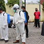 PERSIAPAN: Hudiyono melihat penyemprotan disinfektan di perumahan Desa Bluru Kidul, Sabtu (5/2/2021). foto: ist.