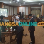 Arif Rosyidi dan Mubin saat menandatangani surat pengesahan usai dilantik menjadi anggota DPRD Gresik PAW periode 2019-2024. Foto: SYUHUD/BANGSAONLINE