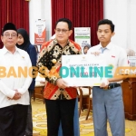 Pj Gubernur Jatim didampingi Ketua Baznas Jatim saat menyerahkan beasiswa program SKSS. Foto: YUDI ARIANTO/BANGSAONLINE