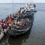 Petugas gabungan mengevakuasi korban yang terbakar di dalam kapal motor Zahro Express di dermaga Muara Angke. foto: Republika