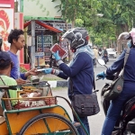 Petugas saat membagikan masker kepada tukang becak. foto: ist.