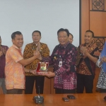 Bupati Sambari memberikan cinderamata kepada Asisten III Pemkab Minahasa Tenggara, Pieter D Owu. foto: SYUHUD/ BANGSAONLINE