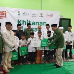 Ketua LAZISNU PBNU Ali Hasan Bahar menyerahkan bingkisan kepada peserta khitanan massal, di aula SMK Plus NU Sidoarjo, Minggu (5/2/2023). Foto: Mustain/BANGSAONLINE.com