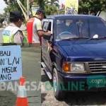 DIPERINGATKAN: Polisi saat melakukan pemeriksaan dan imbauan kepada para pengendara berplat W. Inset: Papan imbauan yang dipasang polisi. foto : dendi martoni/ BANGSAONLINE