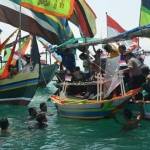 Para nelayan beserta perahunya saat meletakkan sesaji di tengah laut. foto: suwandi/ BANGSAONLINE