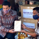 Wali Kota Kediri Abdullah Abu Bakar (kiri) saat menerima pemberian buku jadul dari Budi Santoso di gubuk yang dijadikan semacam perpustakaan. foto: Muji Harjita/ BANGSAONLINE.com