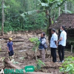 Petugas meninjau kandang milik warga yang terdampak jebolnya tanggul limbah Greenfields. foto: AKINA/ BANGSAONLINE