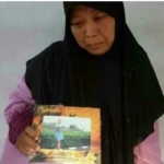 Ibu korban menunjukkan foto anaknya yang menjadi korban gempa di Lombok.