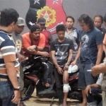 Tersangka (tengah) dengan kaki diperban usai diberi timah panas polisi karena berusaha melarikan diri saat ditangkap. foto: ist